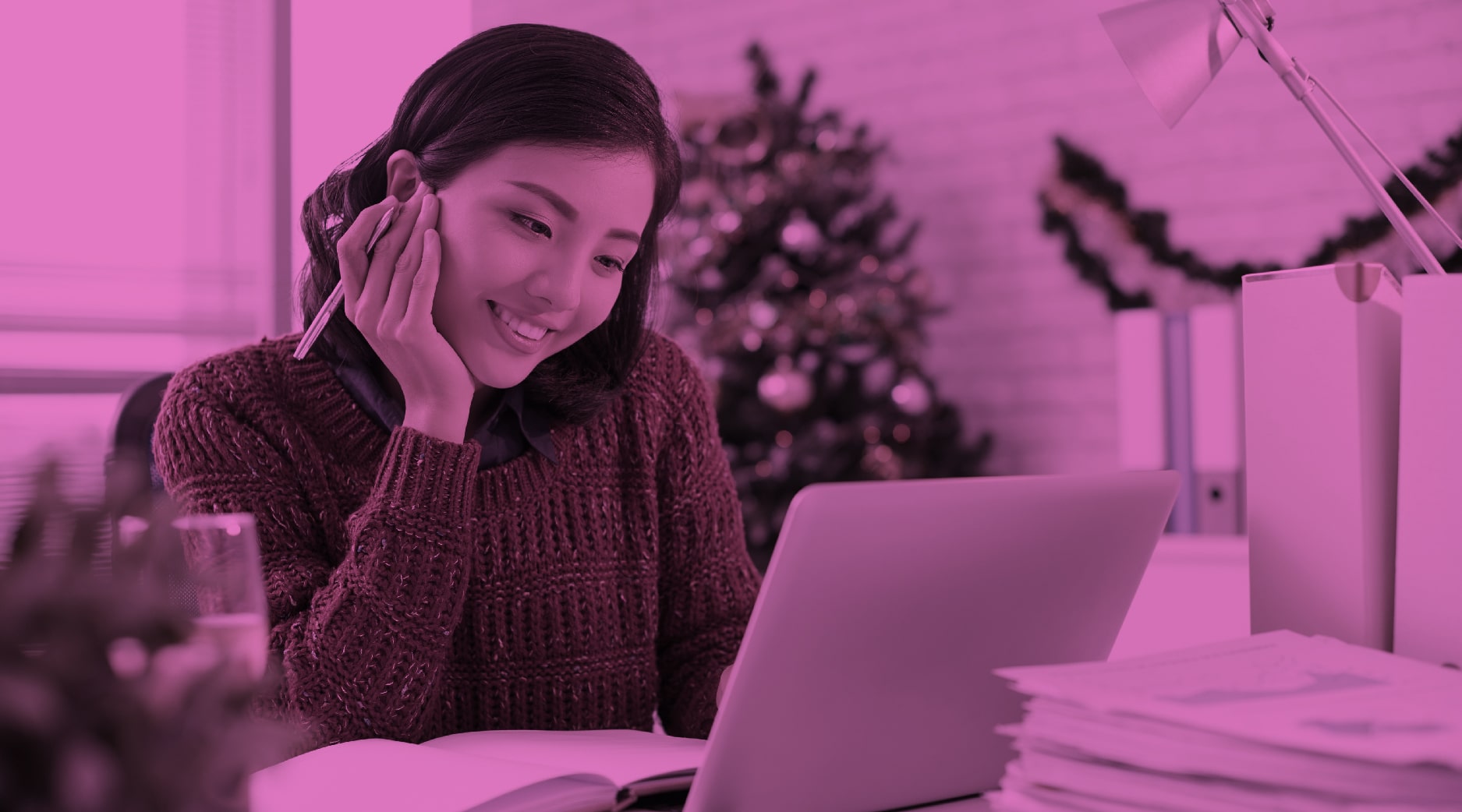 Woman looking at computer in an office decorated for the holidays